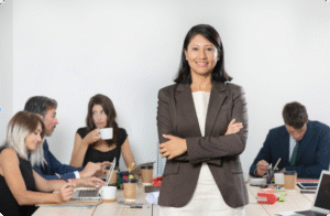 HR professional in brown blazer overseeing team meeting about HR software implementation